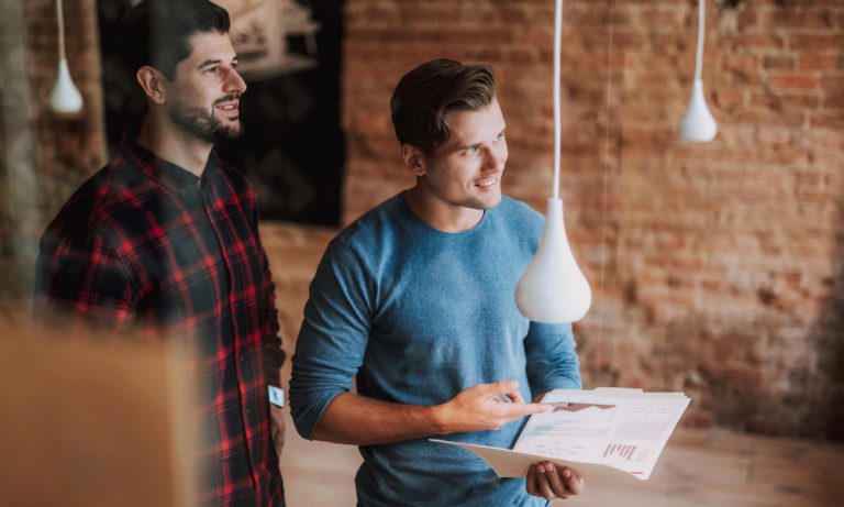 Zwei Mitarbeiter planen die Umwandlung einer Gewerbefläche in Wohnraum